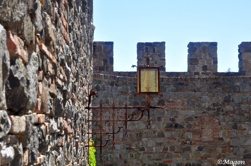 Castello Di Amorosa: каменная стена с ржавым фонарём